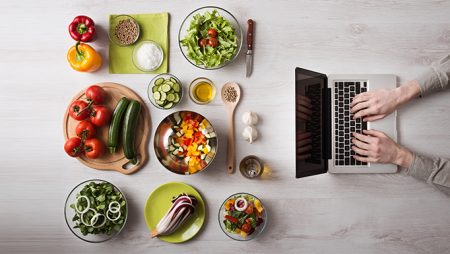 Laptop and multiple plates of food